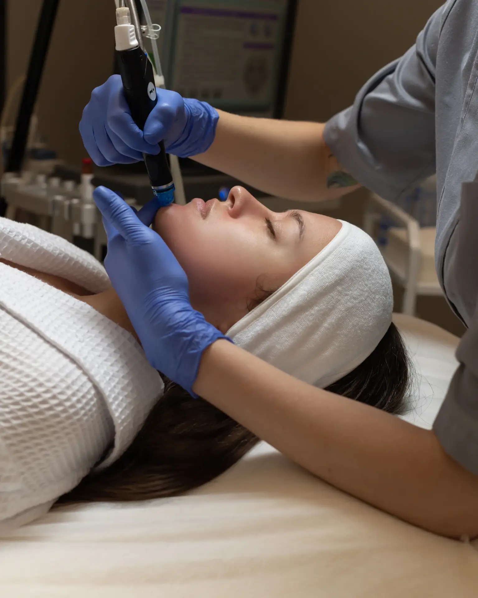 A clinician performing an AquaFirme XS hydrating facial on a reclined patient in South Tempe, AZ