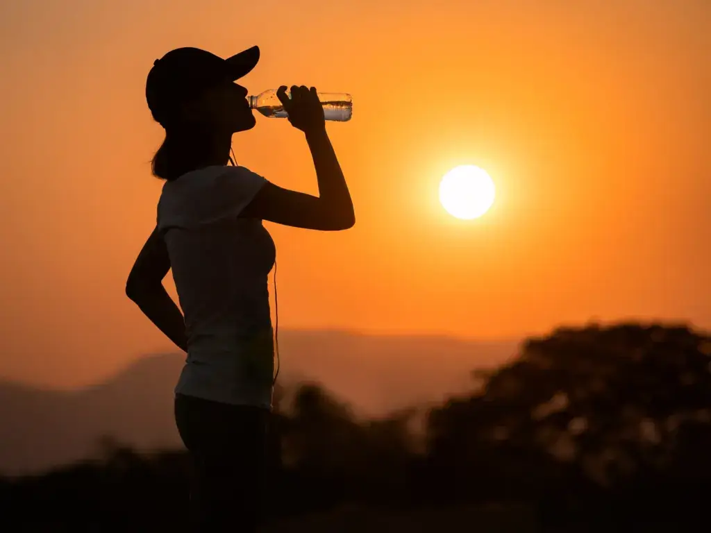 Runner drinking water at sunset during Arizona summer heat