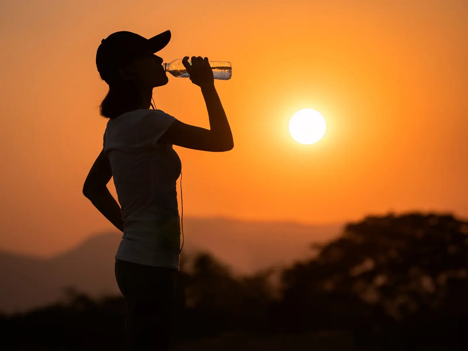 Runner drinking water at sunset during Arizona summer heat
