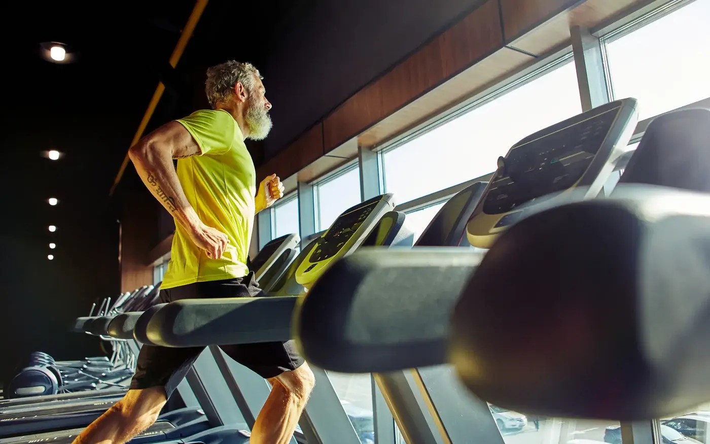 Active middle-aged man running on a treadmill, supported by men's hormone optimization in Tempe
