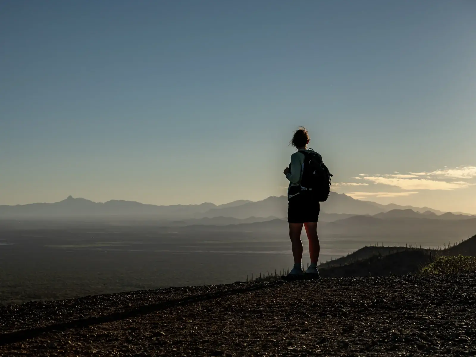 Hiker on a Sonoran Desert ridge in Arizona, where year-round sun affects skin aging