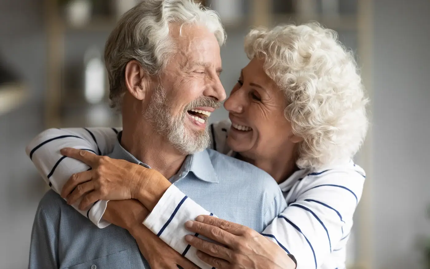 Mature couple embracing and laughing at home, erectile dysfunction care in South Tempe, AZ