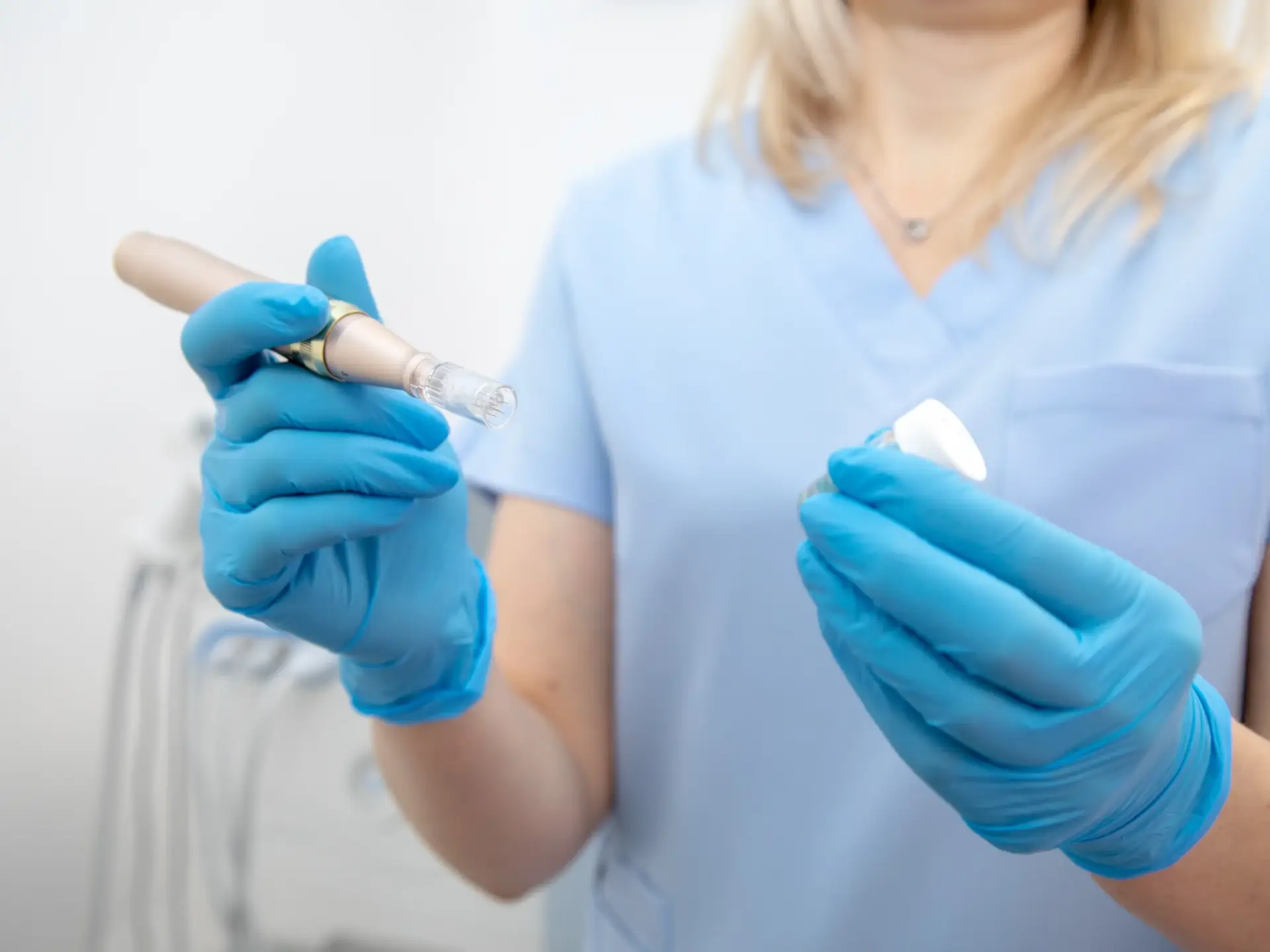 A gloved clinician holding a medical microneedling pen and treatment serum in South Tempe, AZ