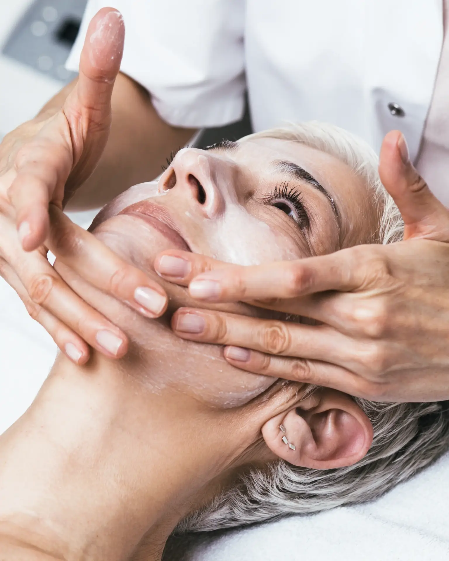 A clinician massaging PRX-T33 solution into a reclined patient face by hand in South Tempe, AZ