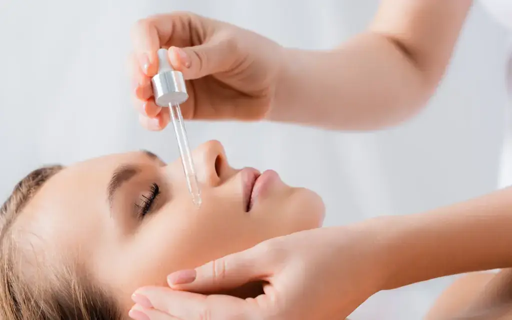 A clinician applying a layer of PRX-T33 solution to a patient face in South Tempe, AZ
