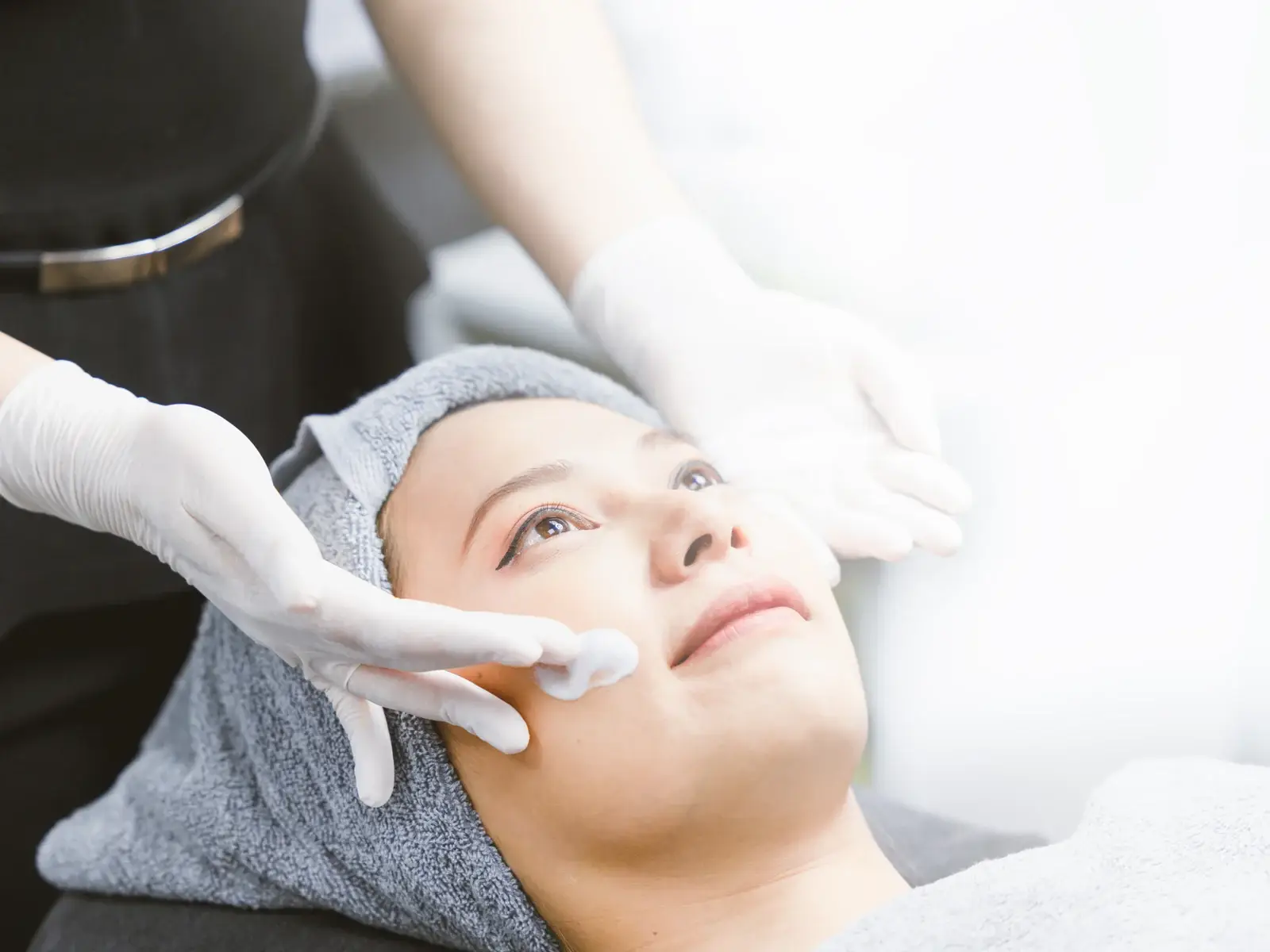 A gloved clinician applying PRX-T33 solution to a patient cheek in South Tempe, AZ