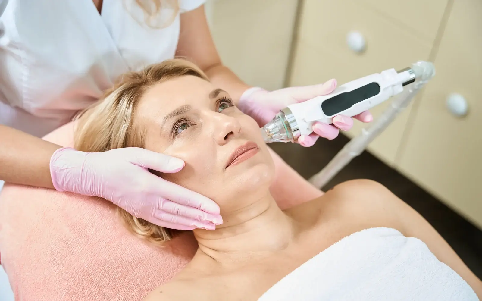 A clinician assessing skin before a Scarlet RF microneedling treatment in South Tempe, AZ