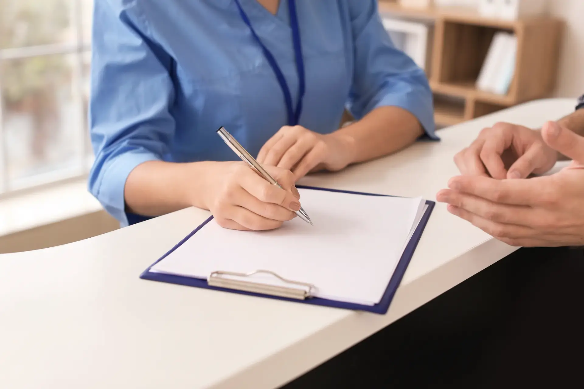 A patient being welcomed at the front desk of a South Tempe, AZ clinic