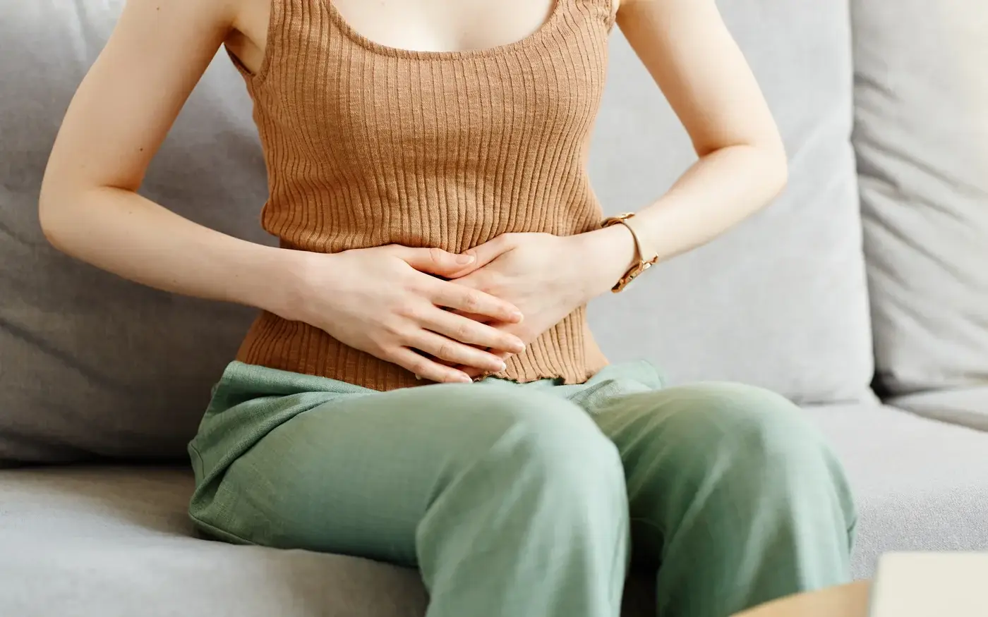 Woman with her hands on her stomach from bloating, gut health care for women in South Tempe, AZ